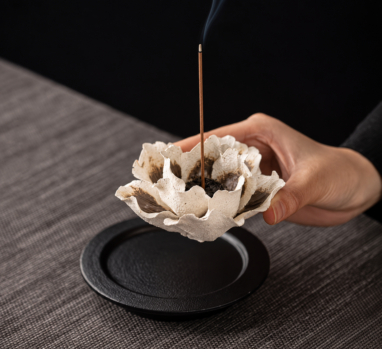 Pale flower-shaped ceramic incense holder shown with a dark tray. Image edited from seller reference.